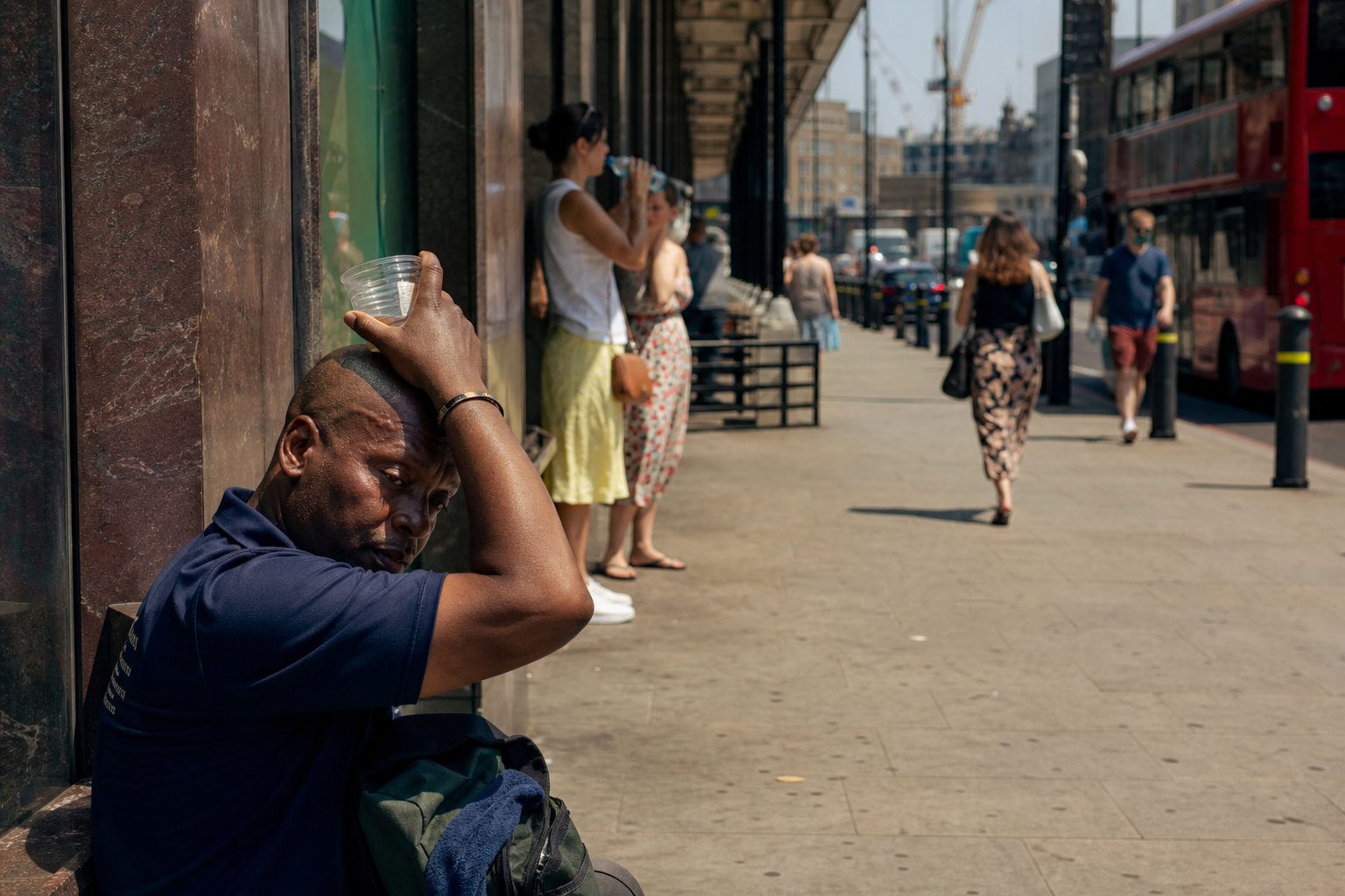 AI-foto van een realistische Britse stad in felle hitte met droog asfalt, waas in de lucht en mensen die schaduw zoeken als beeld bij de naderende hittegolf.