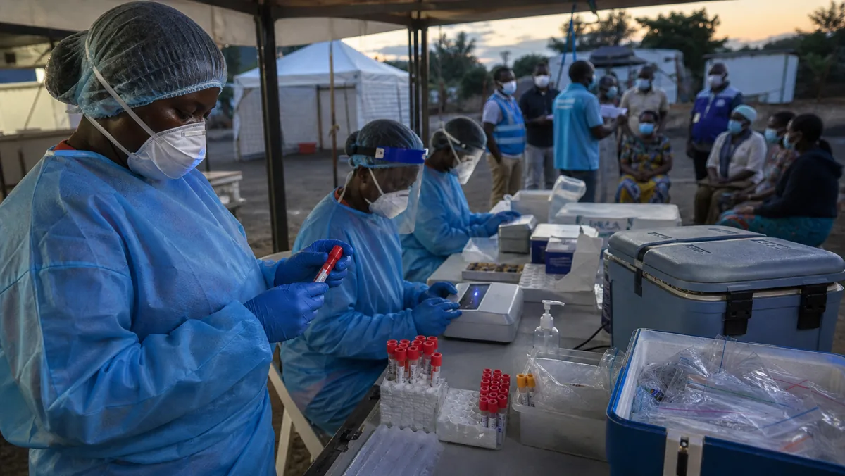 AI-beeld van een veldlaboratorium met anonieme zorgmedewerkers in beschermende kleding en gesloten testmateriaal als illustratie bij WHO Ebola Bundibugyo-diagnostiek.